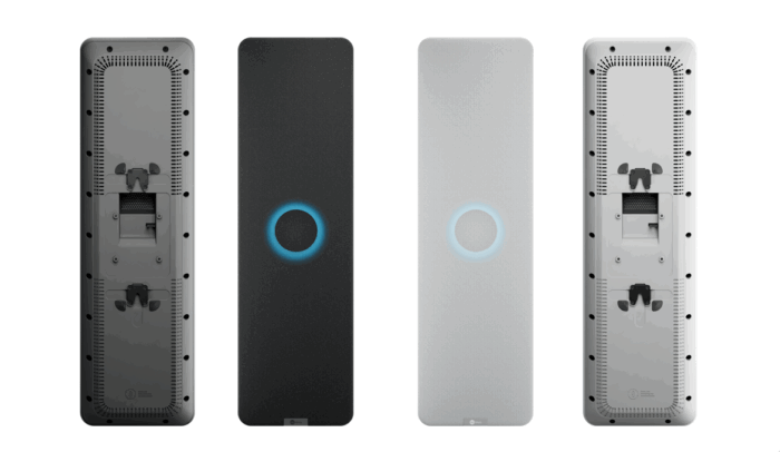 Four tall speakers in a row, showing different finishes; each has a glowing circular LED in the center, including black fabric, matte black, light gray fabric, and gray back panels with ports evident on the ends.